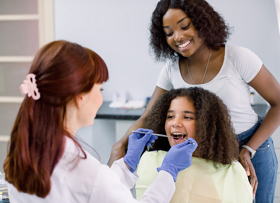 Employee Benefits - Mother Standing by Daughter at a Dental Appointment